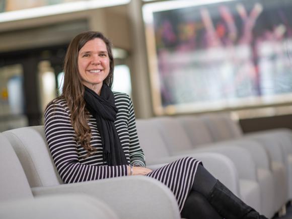 Bethany Mather, a teacher at Farmington River Regional School and alumna of 91ɫ, was recently named this year’s Massachusetts University Educator Alumni Award recipient. She's sitting in the lobby at Horace Mann, in a gray chair. An unfocused window is behind her.