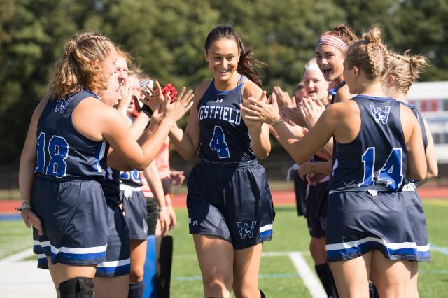 91ɫ State field hockey players high-fiving before a match
