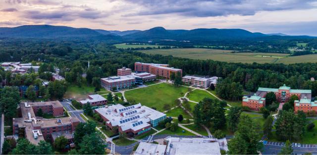 An arial view of the 91ɫ campus, with mountains, forests, and fields in the background.