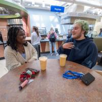 Two students converse and drink smoothies while seated at a table in one of 91ɫ’s on-campus dining facilities.